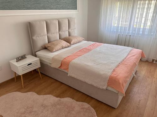 a bedroom with a large bed with a night stand at Darius in Tuzla