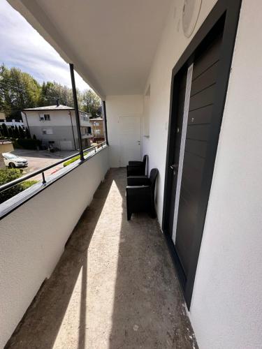 a balcony with two chairs and a door at Darius in Tuzla