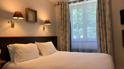 um quarto com uma cama e uma janela em Logis Hôtel Restaurant Grand Hôtel de Lyon em Vals-les-Bains