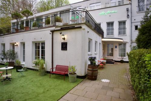 a large white building with a patio and a balcony at Apartmenthaus Hamburg Les Jardins in Hamburg