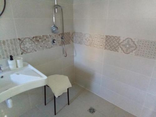 y baño blanco con lavabo y ducha. en LOCANDA DEI FOLLI, en Roccamonfina