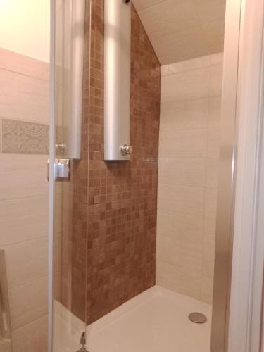 a shower with a glass door in a bathroom at Le Baugyte - Gite de GROUPE - 14 lits simples in Marcigny