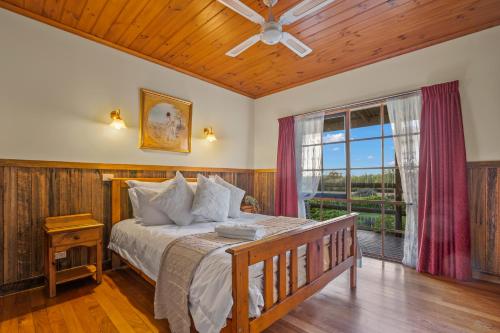 une chambre avec un lit et une grande fenêtre dans l'établissement StayAU Cottage Sunset 2BR Farm Retreat, à Badger Creek