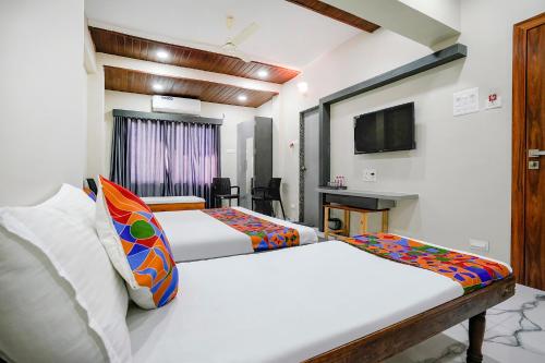 a hotel room with two beds and a television at FabHotel Priya Lodging, near Ojhar Airport in Nashik