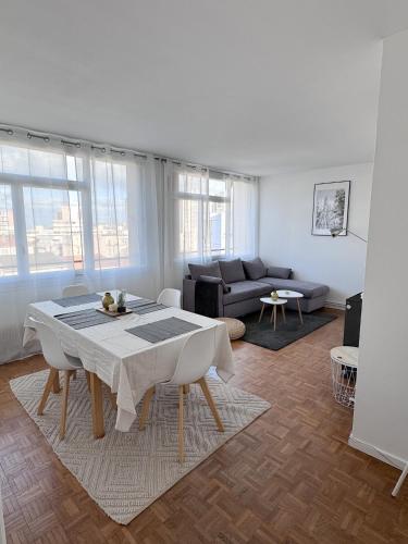 ein Wohnzimmer mit einem Tisch und einem Sofa in der Unterkunft Appartement vue Parc Montjuzet avec garage in Clermont-Ferrand