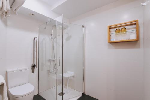 a bathroom with a glass shower stall and a toilet at Hotel Zaragoza Plaza in Donostia-San Sebastián