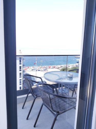 a balcony with a table and chairs and the ocean at Apartmani Aida in Dobra Voda