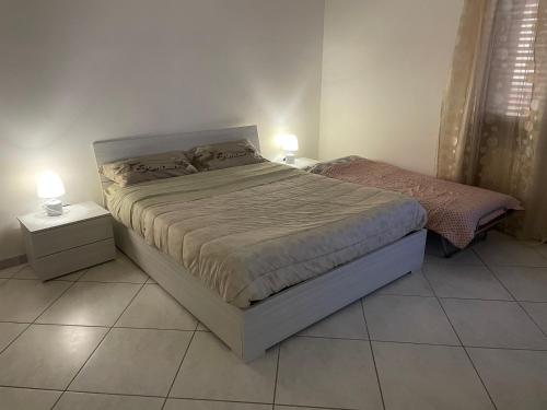 una camera con un letto con due comodini e due lampade di Flora House a Brindisi