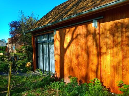 a wooden building with a large sliding glass door at Le Baugyte - Gite de GROUPE - 14 lits simples in Marcigny