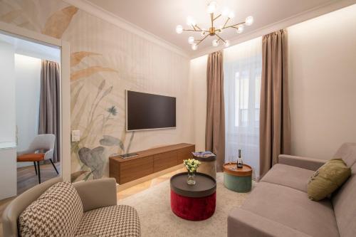 ein Wohnzimmer mit einem Sofa und einem TV in der Unterkunft Novos Emerald - Happy Rentals in Lugano