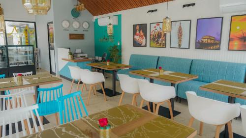 a restaurant with blue booths and tables and chairs at Waterlily Homestay in Kottayam