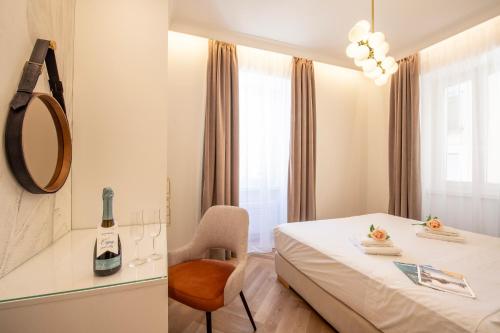 a hotel room with a bed and a chair and a mirror at Novos Central Apartments in Lugano