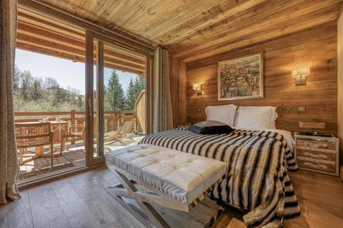 a bedroom with a bed and a balcony at Appartement Chalet à Megève in Megève