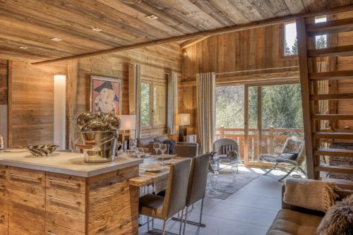 - une salle à manger avec des murs en bois, une table et des chaises dans l'établissement Appartement Chalet à Megève, à Megève