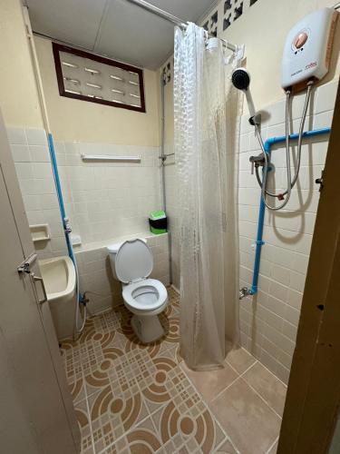 a bathroom with a toilet and a shower with a shower curtain at Achcha hotel - itsaraphap MRT station - Wat Arun in Bangkok