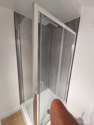 a shower with a glass door in a room at Masfol home from home in Oldham