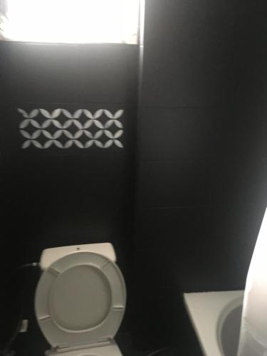 łazienka z białą toaletą i oknem w obiekcie JIM w mieście Andravída