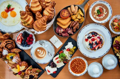 een tafel met daarop borden met eten en kommen met ontbijtproducten bij InterContinental Al Jubail Resort in Al Jubail