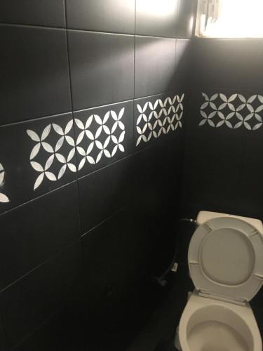 a bathroom with a toilet with black and white tiles at JIM in Andravída