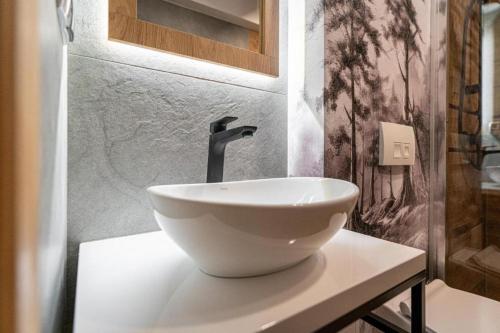 a bathroom with a white bowl sink on a counter at Pensjonat Dawidek in Zakopane