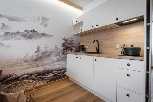 a kitchen with a mural of mountains on the wall at Pensjonat Dawidek in Zakopane