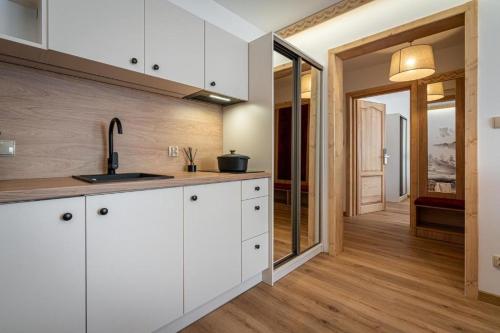a kitchen with white cabinets and a sink at Pensjonat Dawidek in Zakopane