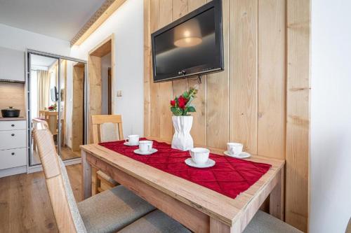 a wooden table with a red table cloth on it at Pensjonat Dawidek in Zakopane