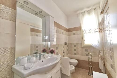La salle de bains est pourvue d'un lavabo, de toilettes et d'un miroir. dans l'établissement Nella spiaggia più bella, à Santa Maria Del Focallo