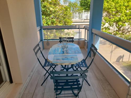 - un balcon avec une table et des chaises sur une terrasse couverte dans l'établissement Appartement T2 à Arcachon - Proche du Casino, Centre-ville, Plage d'Eyrac, Parking et Balcon - FR-1-319-510, à Arcachon