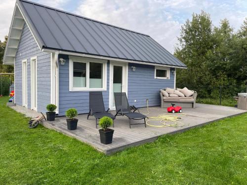 een huis met een terras met 2 stoelen en een bank bij Kiilu puhkemaja in Eametsa