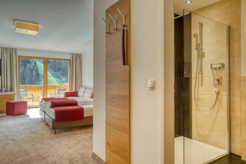 a bathroom with a bed and a shower in a room at Mallaun Hotel.Erlebnis in See