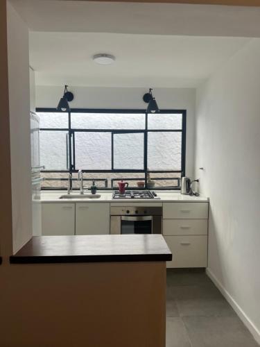 een keuken met een wastafel en een groot raam bij Acacia apartment in San Isidro