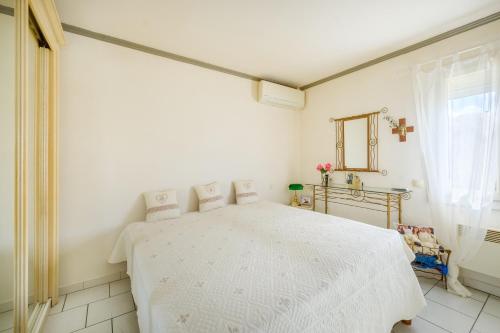une chambre blanche avec un lit blanc dans une pièce dans l'établissement Villa 6 pers avec piscine, à Le Tignet