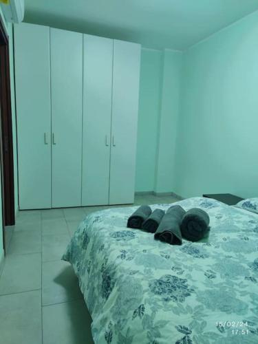 a bedroom with a bed with a green blanket and cabinets at Matis Appartamenti in Camisano