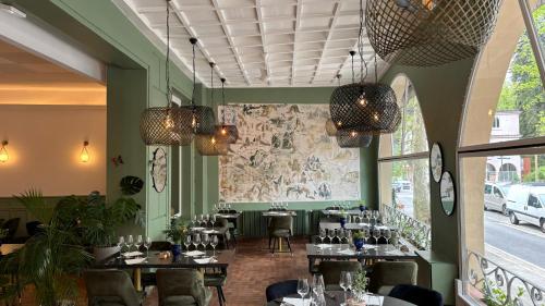 a restaurant with tables and chairs and a large map on the wall at Logis Hôtel Restaurant Grand Hôtel de Lyon in Vals-les-Bains