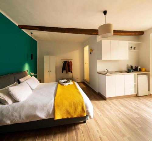 a bedroom with a large bed and a kitchen at All'Ombra della Torre in Viterbo