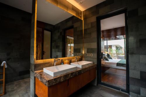 a bathroom with two sinks and a large mirror at Grün Canggu Garden in Canggu