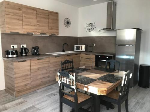 une cuisine avec une table avec des chaises et un réfrigérateur dans l'établissement La Suite des Rêves Bleus, à Saint-Dizier