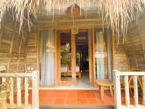 a house with a glass door and chairs in front of it at Umah Suta Sari in Dalung