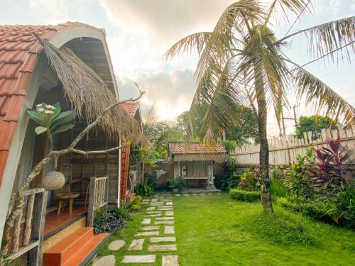 a backyard with a palm tree and a house at Umah Suta Sari in Dalung