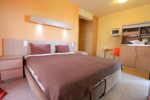 a bedroom with a large bed and a kitchen at elia villa raches in Paralia Rachon