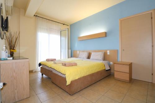 a bedroom with a large bed with a yellow blanket at elia villa raches in Paralia Rachon