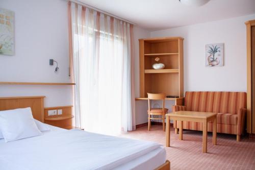 a hotel room with a bed and a chair at Schweigerhof in Ismaning