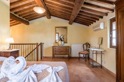 a bedroom with a bed and a desk and a mirror at I Grandi Di Toscana in Ciggiano