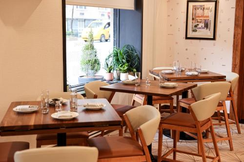 a restaurant with wooden tables and chairs and a window at The Shelburne Sonesta New York in New York