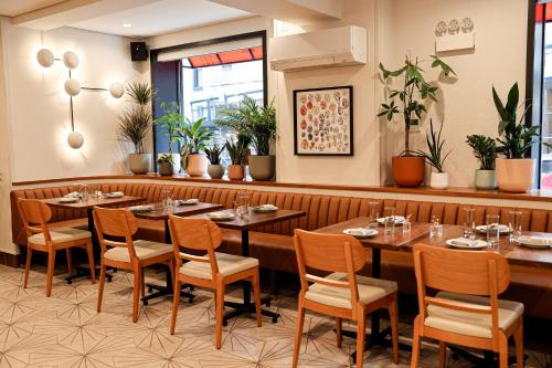 a restaurant with tables and chairs and plants at The Shelburne Sonesta New York in New York