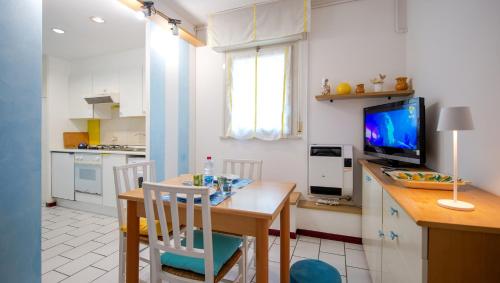 卡托利卡的住宿－Ausonia 10，厨房以及带桌子和电视的用餐室。