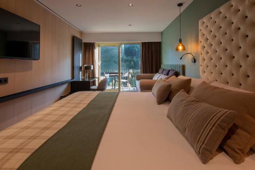 une chambre d'hôtel avec un grand lit et un salon dans l'établissement Hotel Piolets Soldeu Centre, à Soldeu