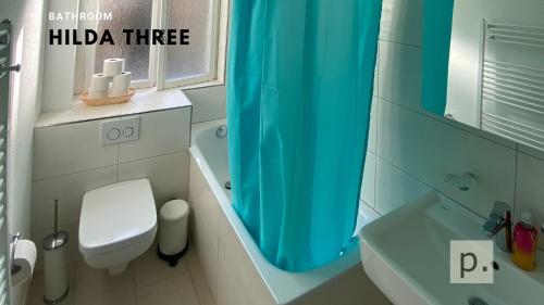 baño con aseo y cortina de ducha azul en H3 with 3,5 rooms, 2 BR, livingroom and big kitchen, modern and central en Zúrich
