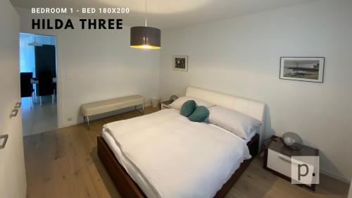 1 dormitorio con 1 cama con sábanas blancas y almohadas verdes en H3 with 3,5 rooms, 2 BR, livingroom and big kitchen, modern and central en Zúrich